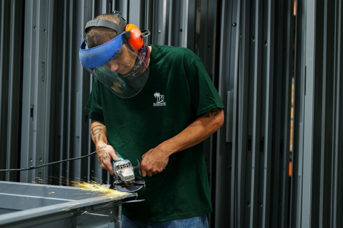 photo of an IPD employee working on a metal door frame