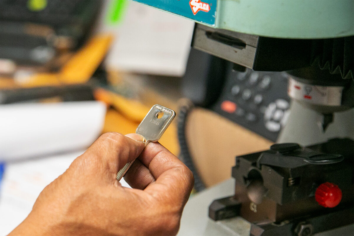 photo of a locksmith checking their work after cutting a new key